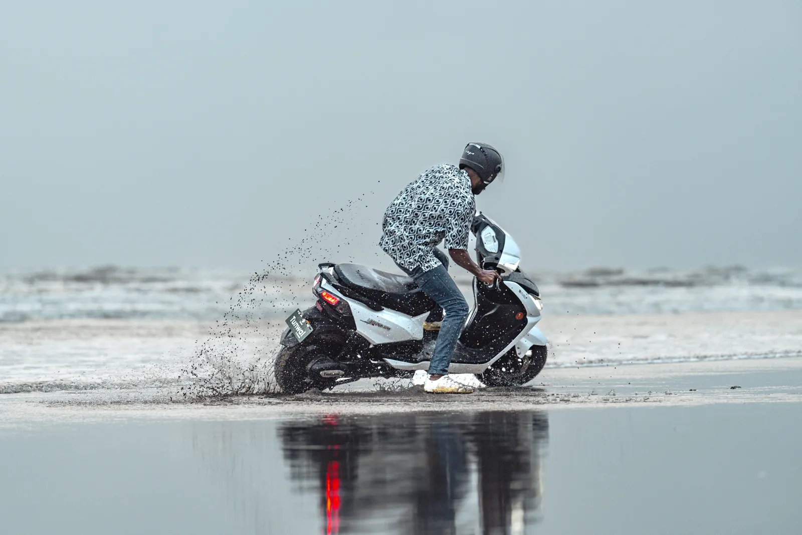A Tunwal electric scooter drifting across a wet beach