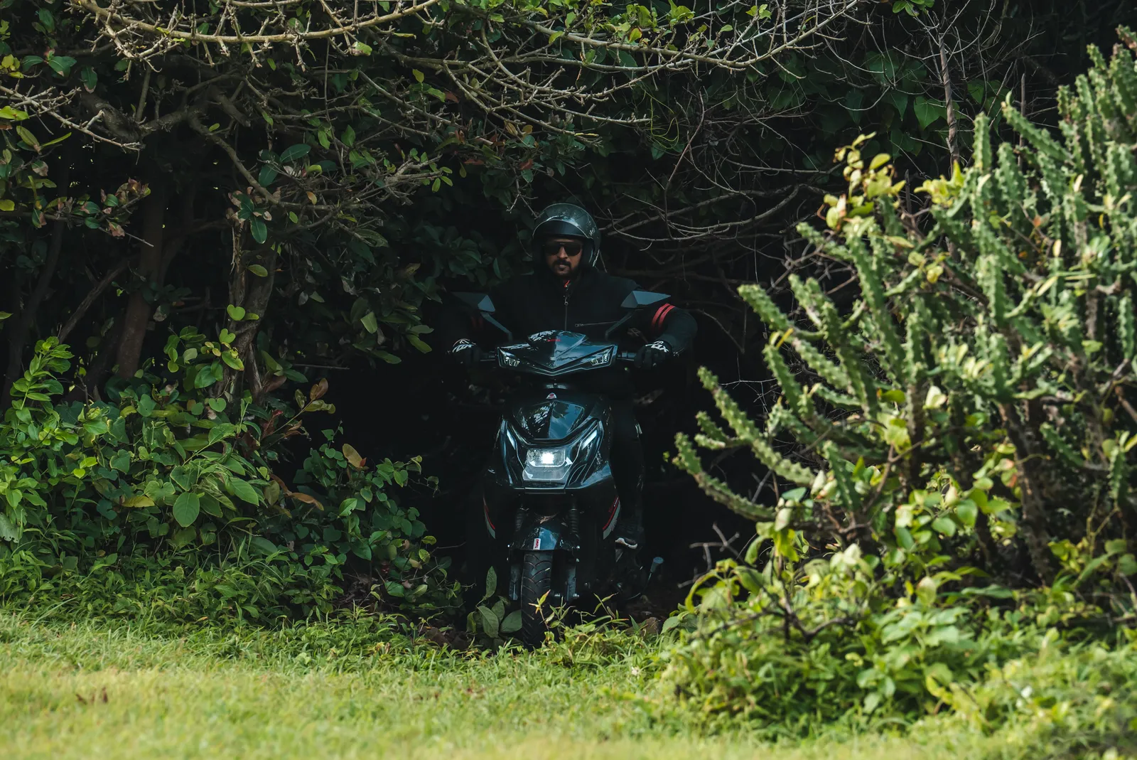 A rider emerging from a jungle trail on a Tunwal scooter