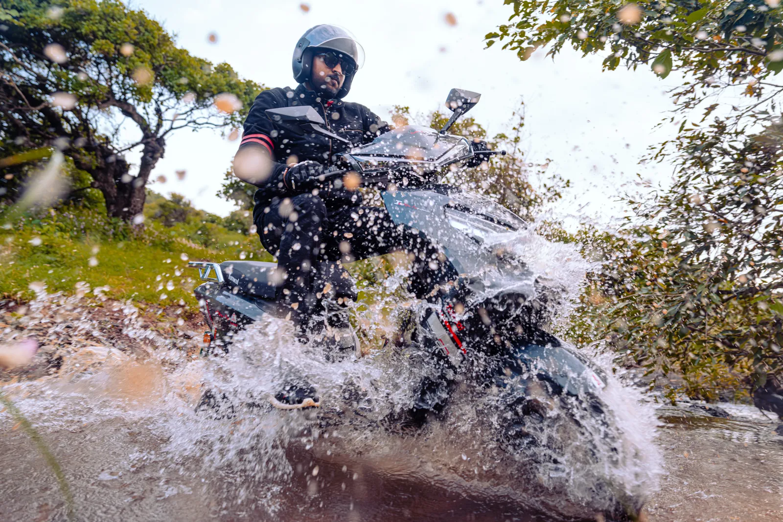 A Tunwal electric scooter powering through water with a splash