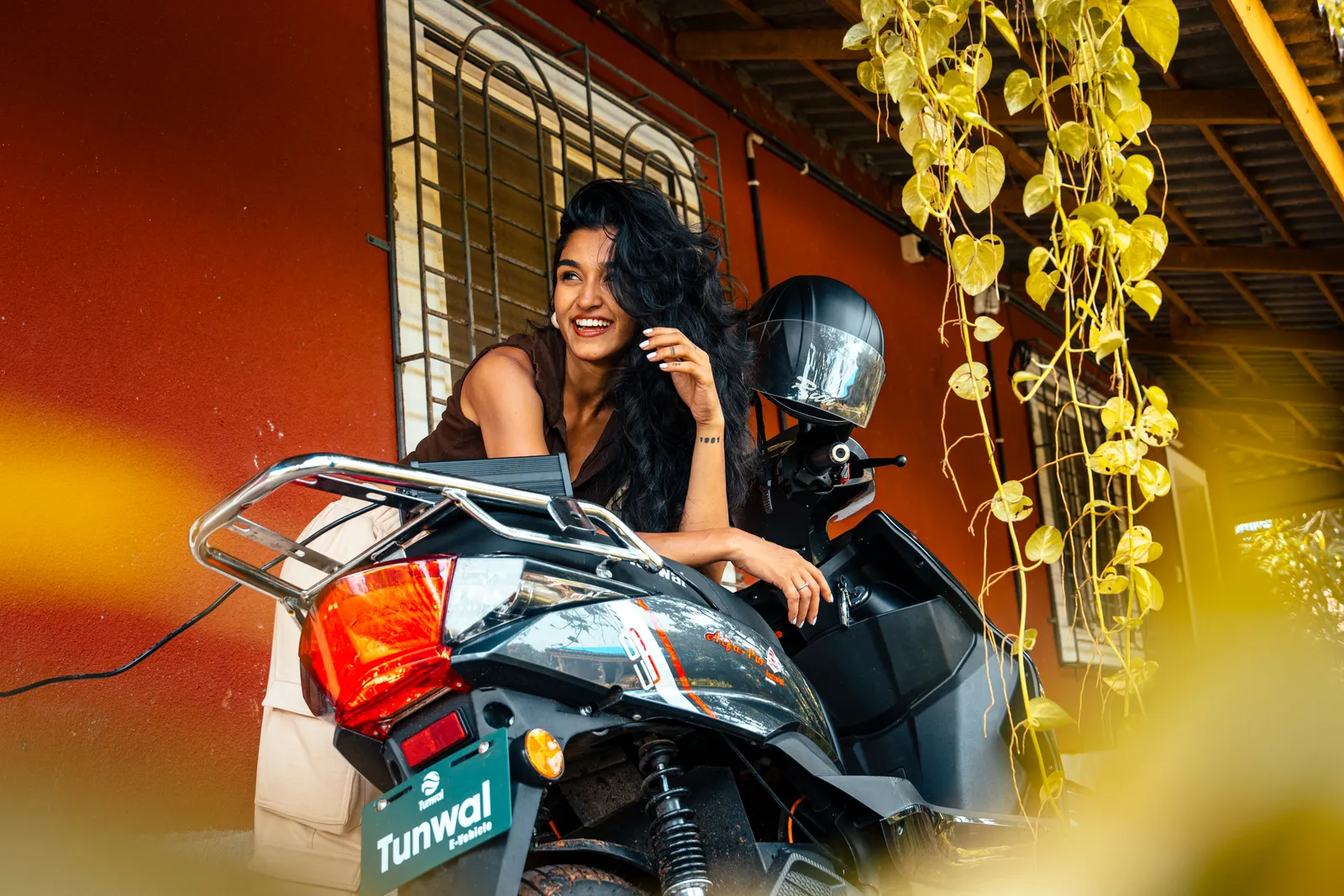 A rider smiling beside her Tunwal electric scooter